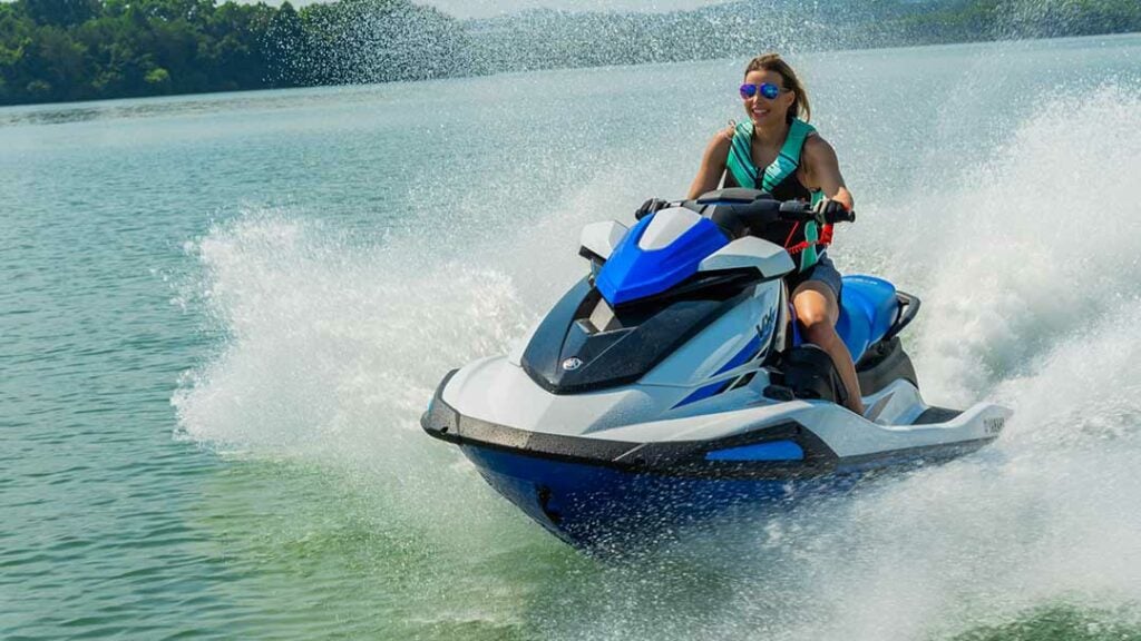 Señora con gafas de sol deslizándose por el mar en una moto acuática Yamaha.